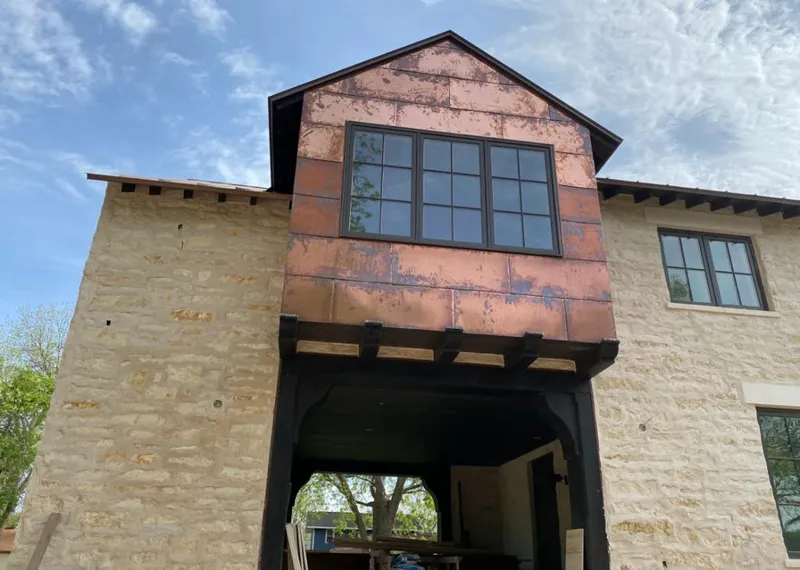 Copper metal panel facade on a stone building for Skylight Installation in Monona